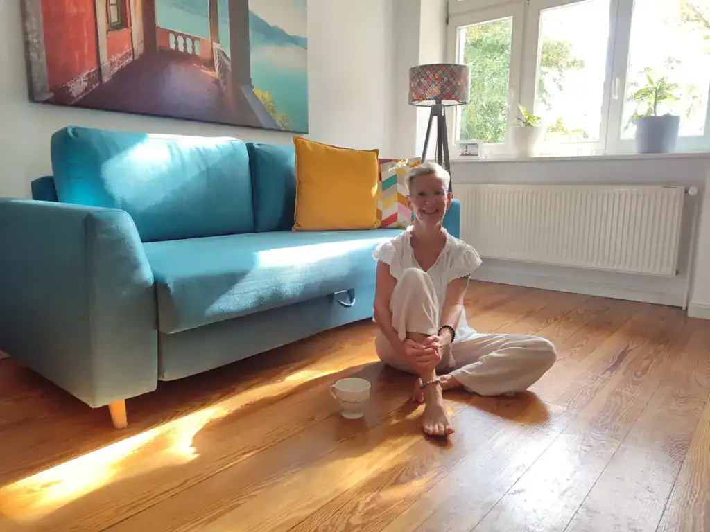 Daniela Bernauer, Elterncoach von KinderLiebe, sitzt entspannt in ihrer Coaching-Umgebung.