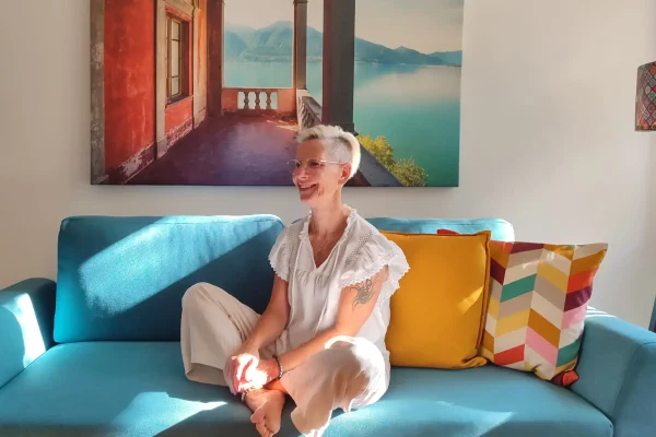 Daniela Bernauer sitzt entspannt auf dem Sofa und lächelt – persönliche Begleitung für Elternfragen, KinderLiebe Blog.