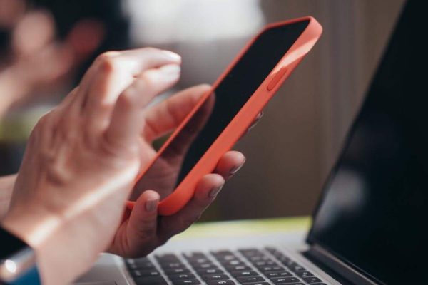 Hand hält Smartphone, liest E-Mail nach Elterncoaching.