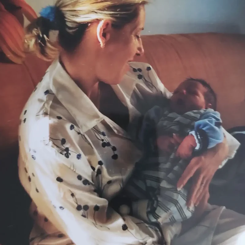 Daniela, Elterncoach bei KinderLiebe, als junge Mutter mit ihrem Neugeborenen im Arm. Ein Moment zu Beginn ihres eigenen Weges als Mutter.