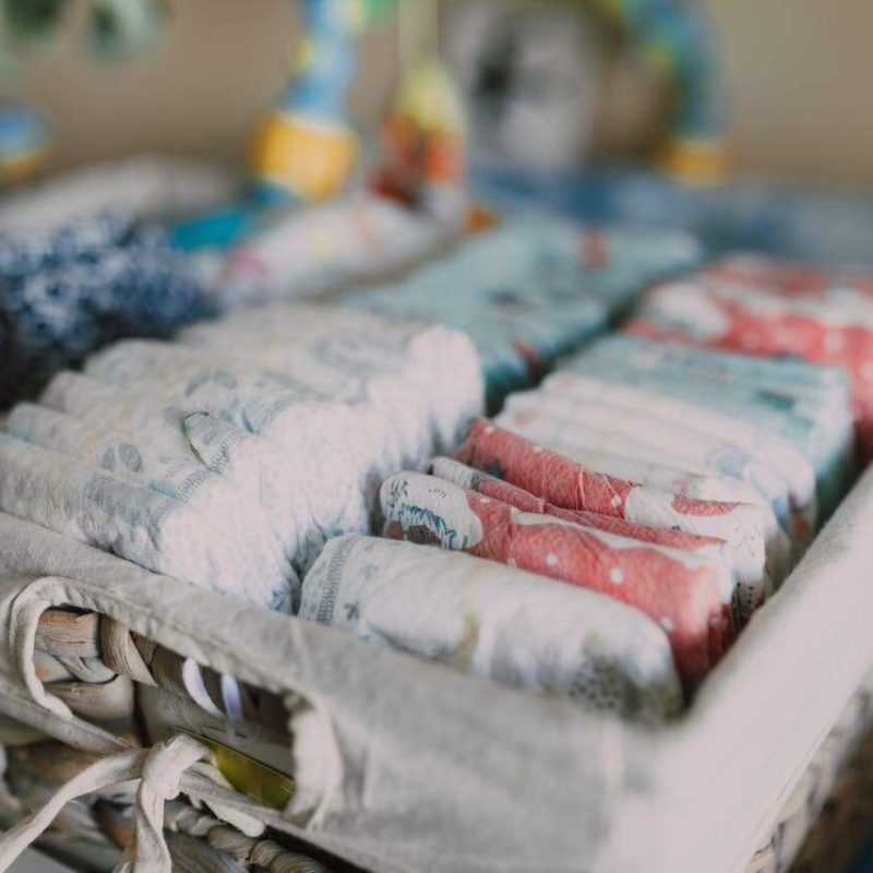 Sortierte bunte Windeln in hellem Korb – Symbol für den Übergang beim Trockenwerden.